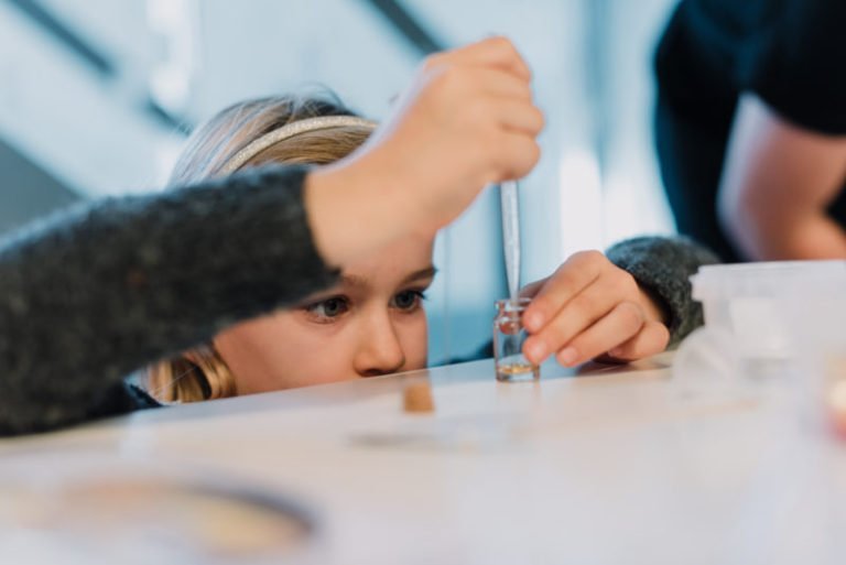 Niña concentrada trabajando con una pipeta
